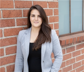 a woman in front of a brick wall